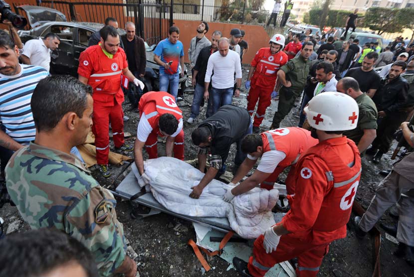 Petugas Palang Merah Lebanon mengevakuasi mayat di lokasi dua ledakan yang meledak dekat Kedutaan Besar Iran di Beirut, Lebanon, Selasa (19/11). (AP/Hussein Malla)