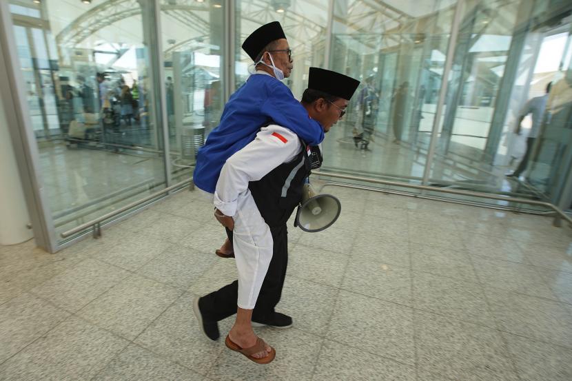 Petugas Panitia Penyelenggara Ibadah Haji (PPIH) membantu calon haji kloter pertama dari embarkasi Jakarta Bekasi. (ilustrasi)