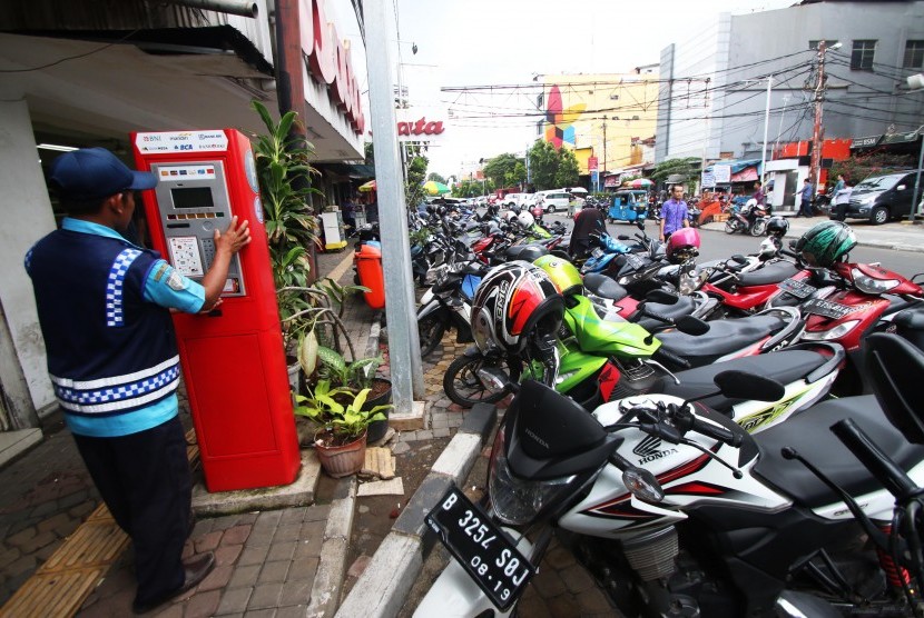 Petugas parkir mengoperasikan mesin meteran parkir di Jakarta, Jumat (12/2).