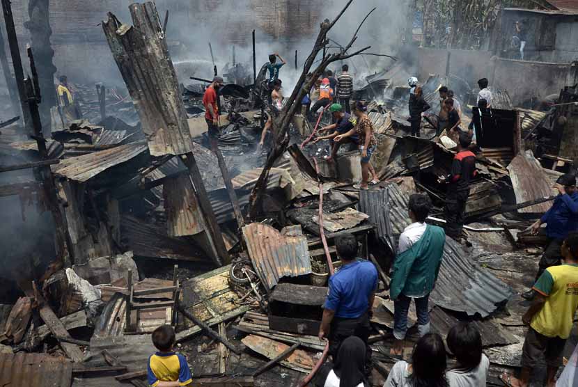  Petugas pemadam berupaya memadamkan sisa kobaran api saat musibah kebakaran perumahan padat penduduk yang terjadi di jalan Kerung-kerung, Bararayya Utara, Makassar, Makassar, Sulsel, Kamis (27/3). (Antara/Dewi Fajriani)