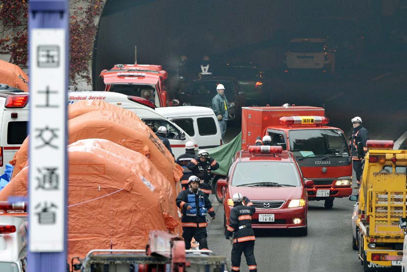 Petugas pemadam kebakaran bekerja di pintu keluar dari ruas terowongan Sasago dalam jalur Chuo Expressway di Jepang ,Senin (3/12).  (AP/Kyodo News) 