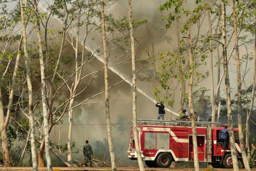 Petugas pemadam kebakaran bersama prajurit TNI memadamkan api yang membakar hutan di Kabupaten Aceh Besar, Aceh.