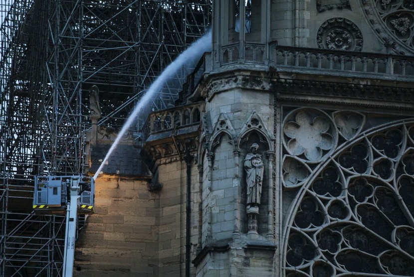 Petugas pemadam kebakaran berupaya memadamkan api di Katedral Notre-Dame di Paris, Prancis, Selasa (16/4).