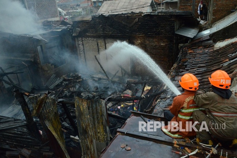 Petugas pemadam kebakaran berusaha memadamkan api di permukiman padat penduduk di daerah Karees Kulon RW 06, Kelurahan Malabar, Kecamatan Lengkong, Kota Bandung, Kamis (3/5).