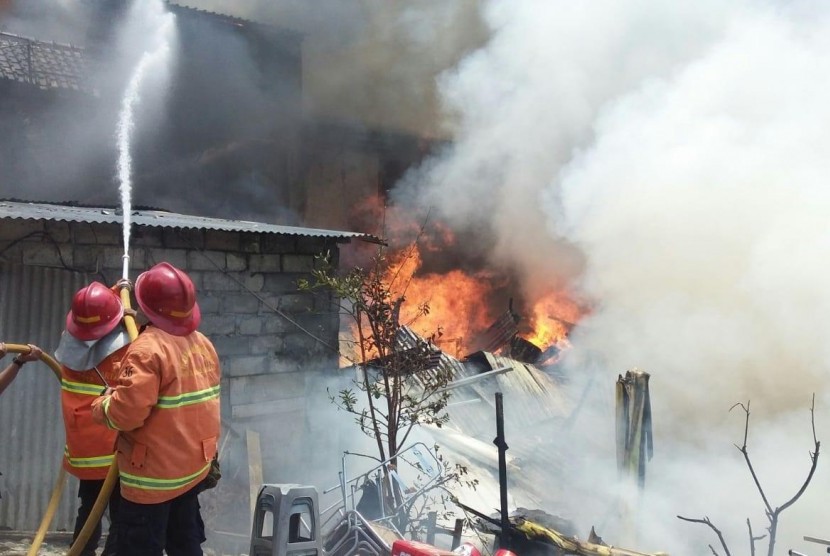  Petugas pemadam kebakaran berusaha memadamkan api di salah satu  gudang yang terbakar di kawasan prostitusi tepatnya di Jalan Pasar Kembang,  Yogyakarta, Rabu (2/10).