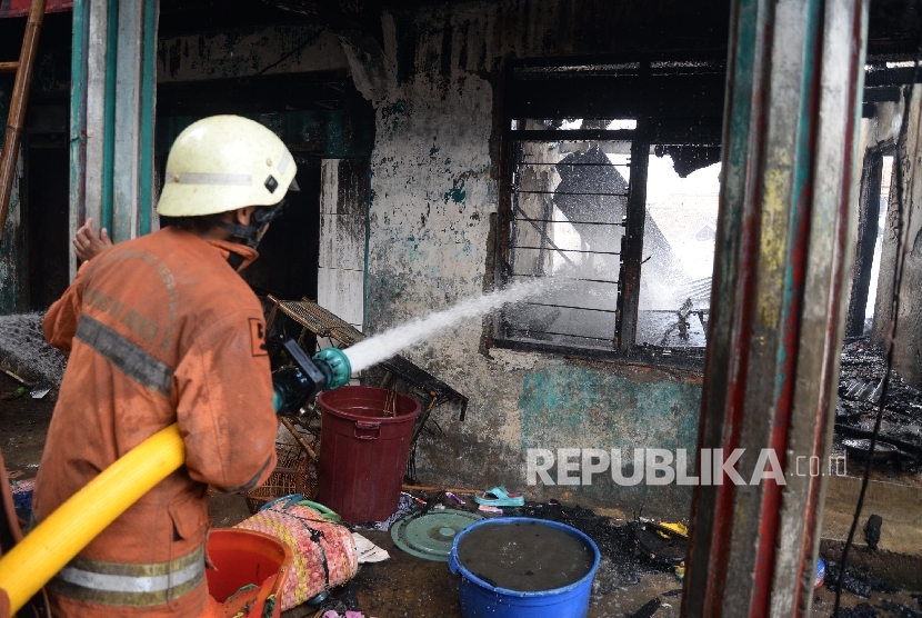 Petugas pemadam kebakaran berusaha memadamkan api ketika terjadi kebakaran di kawasan pemukiman rumah di pinggiran Sungai Ciliwung, Bukit Duri, Jakarta Selatan, Selasa (23/2).(Republika/Yasin Habibi)