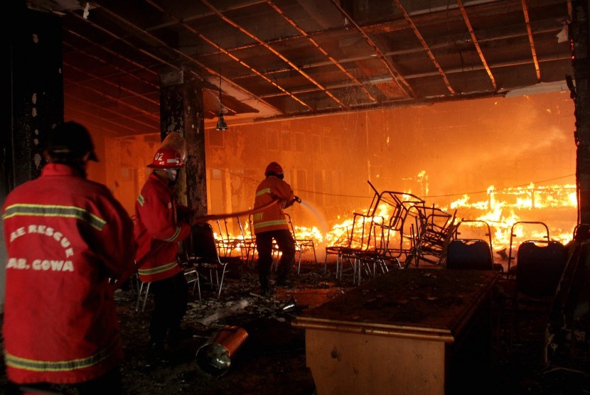 Petugas pemadam kebakaran berusaha memadamkan api saat kebakaran di kantor DPRD Kabupaten Gowa, Sulawesi Selatan, Senin (26/9).
