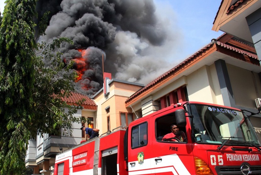 Petugas pemadam kebakaran berusaha memadamkan api saat kebakaran di kantor DPRD Kabupaten Gowa, Sulawesi Selatan, Senin (26/9). 