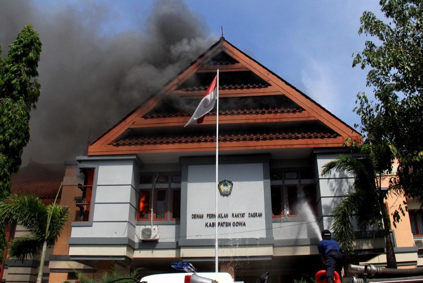 Petugas pemadam kebakaran berusaha memadamkan api saat kebakaran di kantor DPRD Kabupaten Gowa, Sulawesi Selatan, Senin (26/9). 