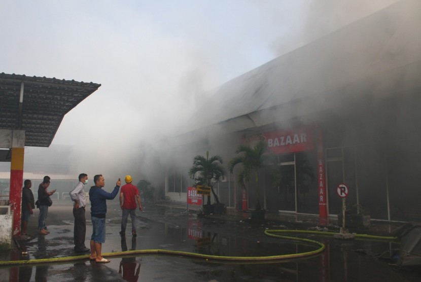 Petugas Pemadam Kebakaran berusaha memadamkan api yang membakar kios di Pasar Besar Malang, Jawa Timur, Kamis (26/5).