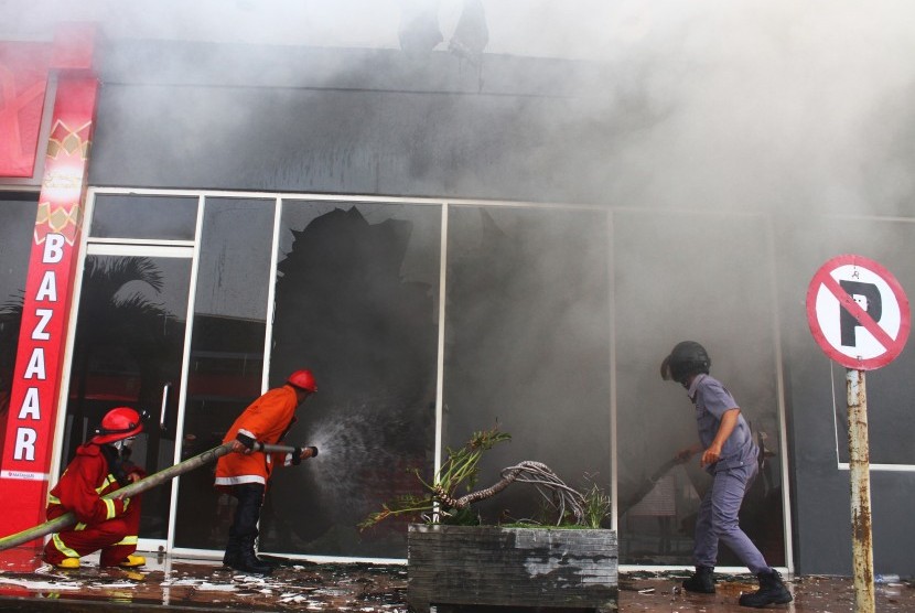 Petugas Pemadam Kebakaran berusaha memadamkan api yang membakar kios di Pasar Besar Malang, Jawa Timur, Kamis (26/5). 