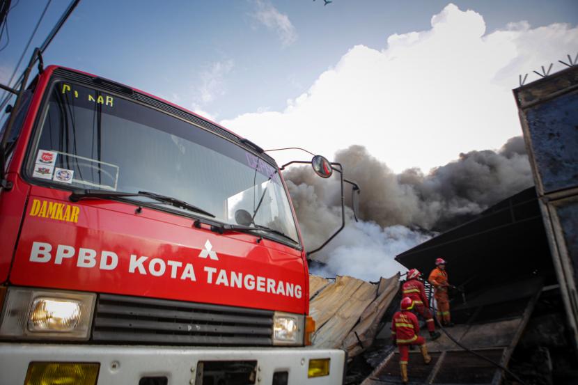 Petugas pemadam kebakaran berusaha memadamkan api yang membakar pabrik paralon di Kosambi, Kabupaten Tangerang, Provinsi Banten, Jumat (15/7/2022). 