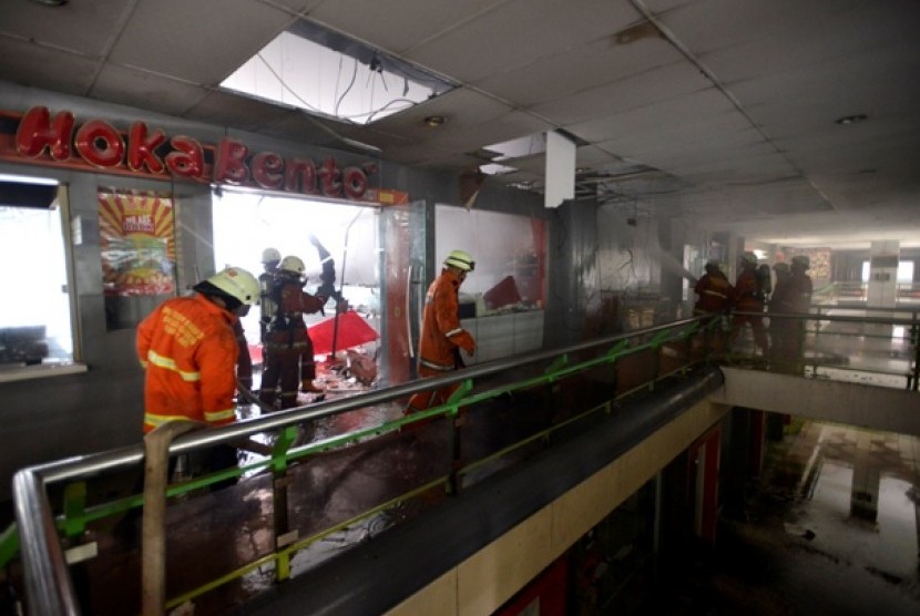 Petugas pemadam kebakaran berusaha memadamkan api yang membakar sebuah restoran cepat saji di Stasiun Gambir, Jakarta Pusat, Jumat (27/12). 