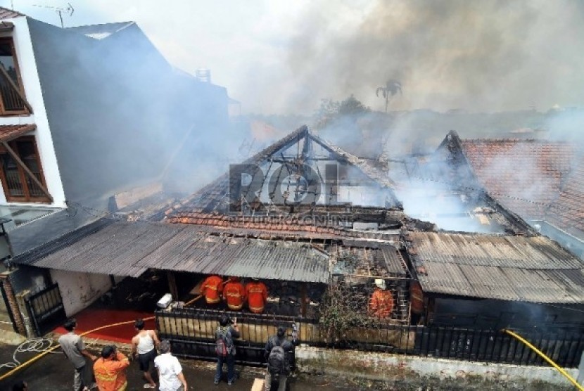 Petugas pemadam kebakaran berusaha memadamkan api yang menghanguskan sebuah rumah di Jalan Palem, Pasar Minggu, Jakarta Selatan, Senin (23/2).  