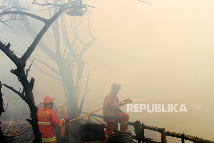 Petugas pemadam kebakaran berusaha memadamkan sisa api saat terjadi kebakaran di kawasan permukiman penduduk, di Cipinang Muara, Jakarta, Senin (21/5).