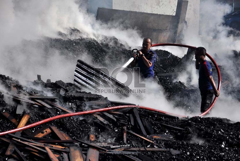 Petugas pemadam kebakaran berusaha memadamkan sisa api yang membakar gudang kayu dan bengkel mebel di Cimanggis, Depok, Jawa Barat, Senin (18/3).  (Republika/Rakhmawaty La'lang)