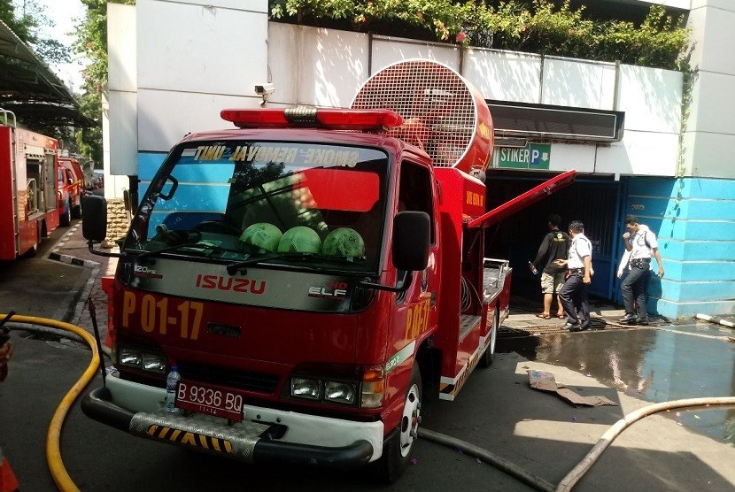 Petugas pemadam kebakaran berusaha memadamkan sisa-sisa kebakaran di Gedung Kementerian Perhubungan di Jakarta, Ahad (8/7).