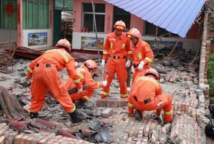 Petugas pemadam kebakaran cina mencoba mengevakuasi korban dari balik dinding bangunan yang runtuh. Gempa kembar mengguncang negara itu pada Jumat (7/9/2012)