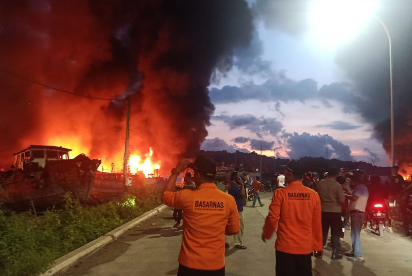 Petugas pemadam kebakaran dan basarnas tengah memadamkan api dari ledakan kapal di dermaga Wijayapura, Cilacap. 