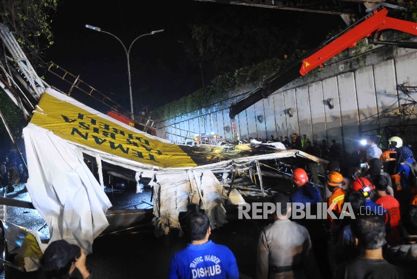 Petugas pemadam kebakaran dan Dishub berusaha mengevakuasi jembatan penyebrangan orang (JPO) yang ambruk di Pasar Minggu, Jakarta, Sabtu (24/9).