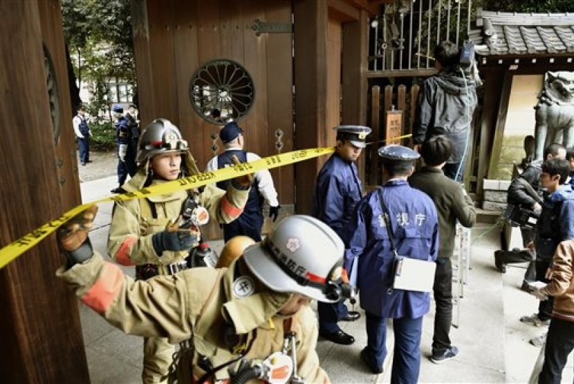 Petugas pemadam kebakaran dan polisi memeriksa kuil tempat terjadi ledakan di kuil Yasukuni, Tokyo, Senin (23/11).