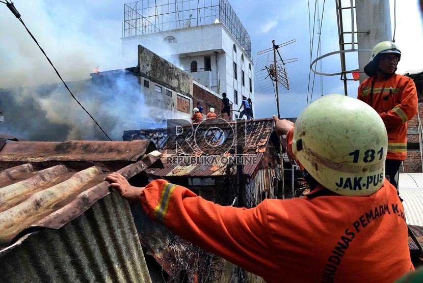  Petugas Pemadam kebakaran dibantu warga berusaha memadamkan rumah yang terbakar di Jalan Salemba, Senen, Jakarta Pusat, Selasa (12/3).   (Republika/ Agung Supriyanto)