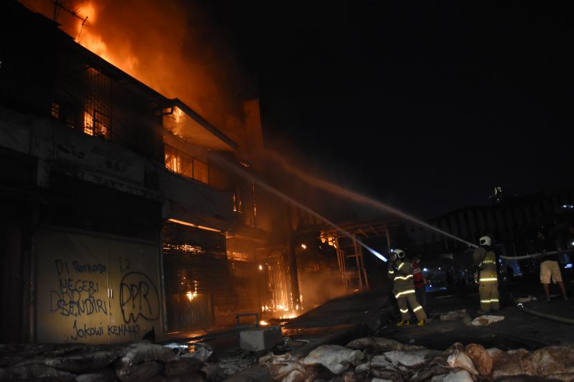 Petugas Pemadam Kebakaran dibantu warga memadamkan api yang menghanguskan bangunan di kawasan Senen, Jakarta.