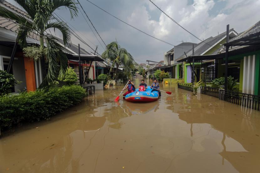 Petugas membawa warga dengan perahu karet untuk melintasi banjir di Perumahan Mutiara Hijau Residen, Pakansari, Cibinong, Kabupaten Bogor, Selasa (16/8/2022). (Ilustrasi)