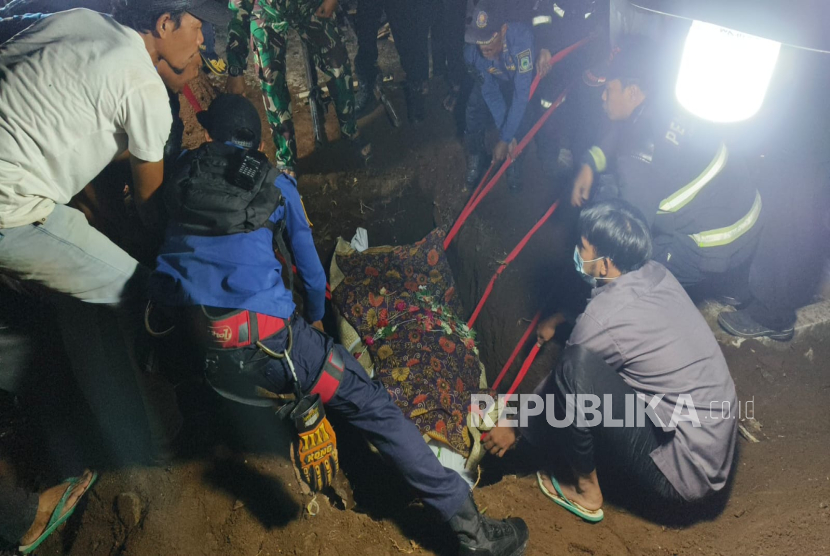 Petugas pemadam kebakaran Kabupaten Kuningan membantu pemakaman jenazah warga yang mengalami obesitas dengan berat sekitar 200 kilogram, di Desa Pesing, Kecamatan Jalaksana, Kabupaten Kuningan, Senin (13/10/2025) malam. 