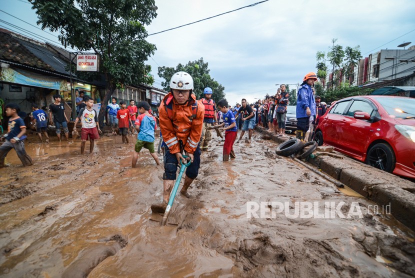 Petugas pemadam kebakaran Kota Bandung membersihkan lumpur akibat banjir bandang di Jalan A.H Nasution, Bandung, Jawa Barat, Selasa (20/3).