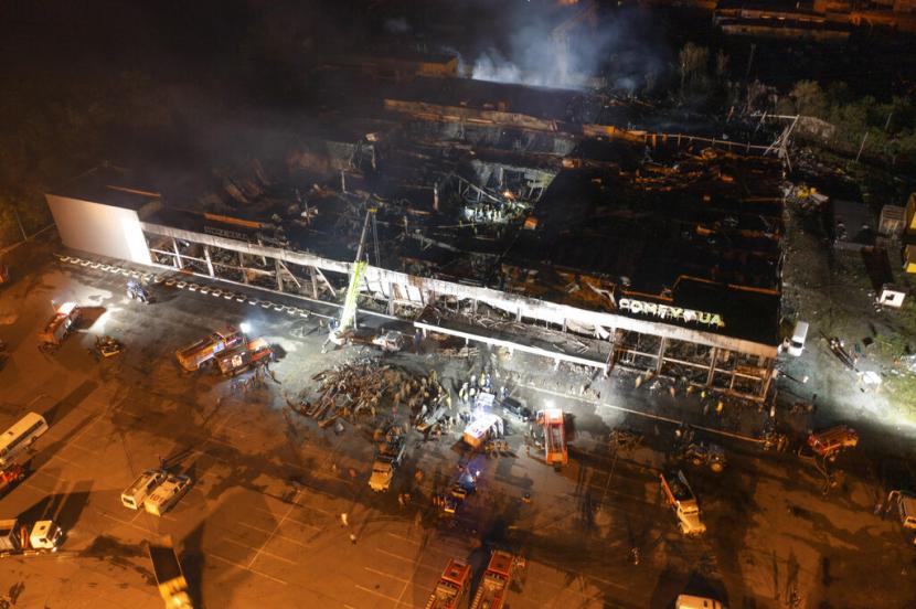 Petugas pemadam kebakaran Layanan Darurat Negara Ukraina bekerja untuk memadamkan api di pusat perbelanjaan yang terbakar setelah serangan roket di Kremenchuk, Ukraina, Senin malam, 27 Juni 2022.