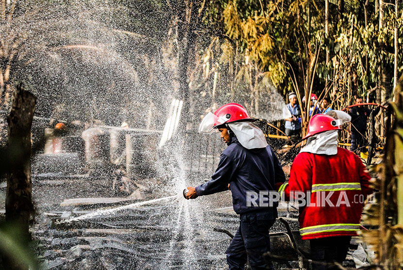 Petugas pemadam kebakaran melakukan pendinginan area ledakan sumur minyak ilegal pasca api padam di Desa Pasir Putih, Rantau Pereulak, Aceh Timur, Aceh, Kamis (26/4). 