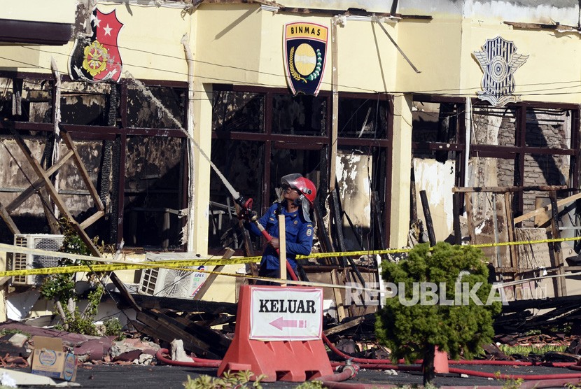 Petugas pemadam kebakaran melakukan pendinginan di beberapa ruangan Kantor Polres Lampung Selatan yang terbakar di Lampung, Kamis (2/5/2019).