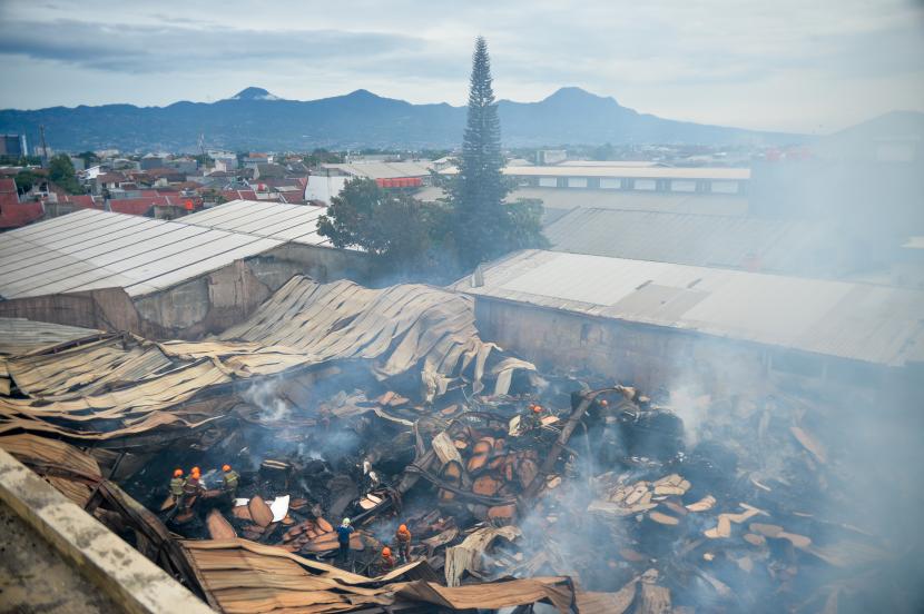 Petugas pemadam kebakaran melakukan pendinginan gudang triplek yang terbakar di Jalan Soekarno-Hatta, Cijagra, Bandung, Jawa Barat, Rabu (26/10/2022). Petugas berhasil memadamkan api yang membakar gudang triplek setelah berjibaku menjinakkan api selama 37 jam. 