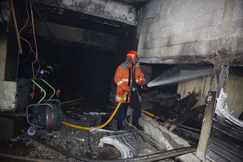 Petugas pemadam kebakaran melakukan pendinginan saat kebakaran di basement Gedung Direktorat Pajak di Jakarta, Jumat (31/7).    (Antara/Hafidz Mubarak A)
