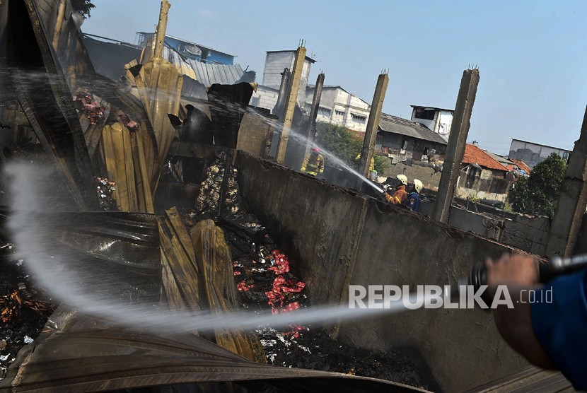 Petugas pemadam kebakaran melakukan pendinginan saat terjadi kebakaran di Jalan Jati Bundar, Tanah Abang, Jakarta, Ahad (30/6/2019).