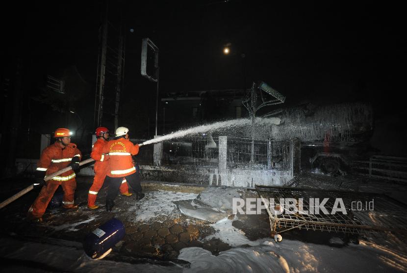 Petugas pemadam kebakaran melakukan pendinginan terhadap truk tangki bermuatan BBM yang terbakar di SPBU kawasan Jagakarsa,Jakarta,Sabtu (30/12). 