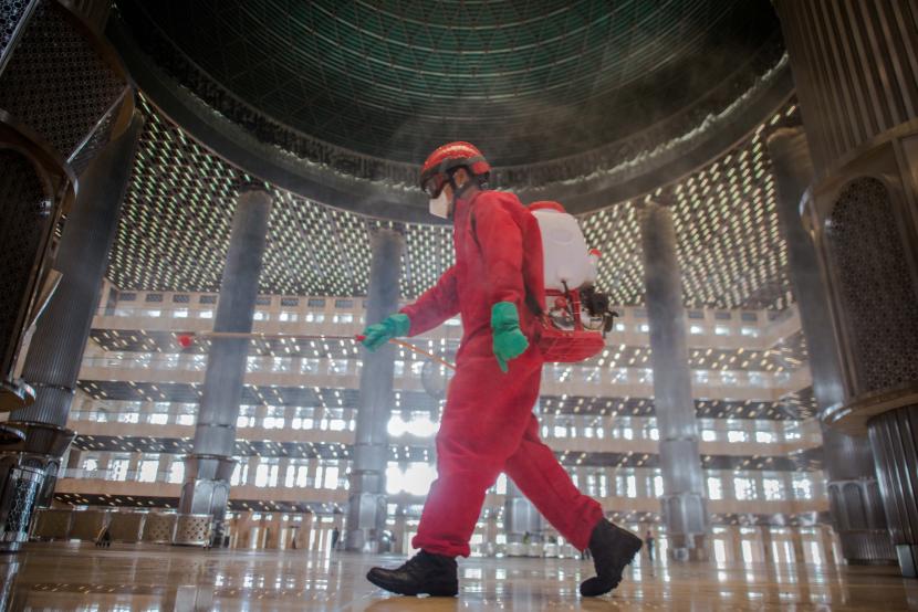 Petugas pemadam kebakaran melakukan penyemprotan cairan disinfektan di Masjid Istiqlal, Jakarta.