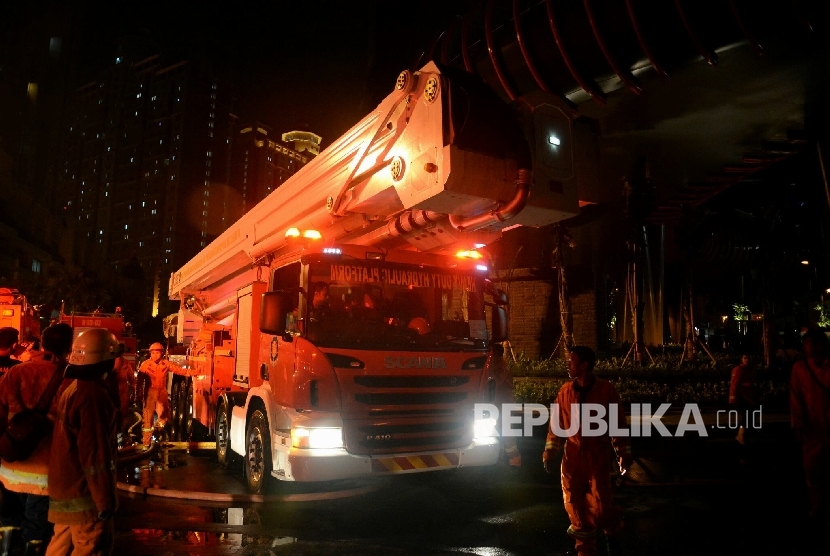 Petugas pemadam kebakaran melakukan proses pendinginan pada gedung apartemen Neo Soho yang terbakar, Jakarta, Rabu (9/11) malam