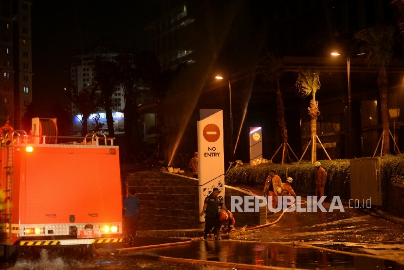 Petugas pemadam kebakaran melakukan proses pendinginan pada gedung apartemen Neo Soho yang terbakar, Jakarta, Rabu (9/11) malam