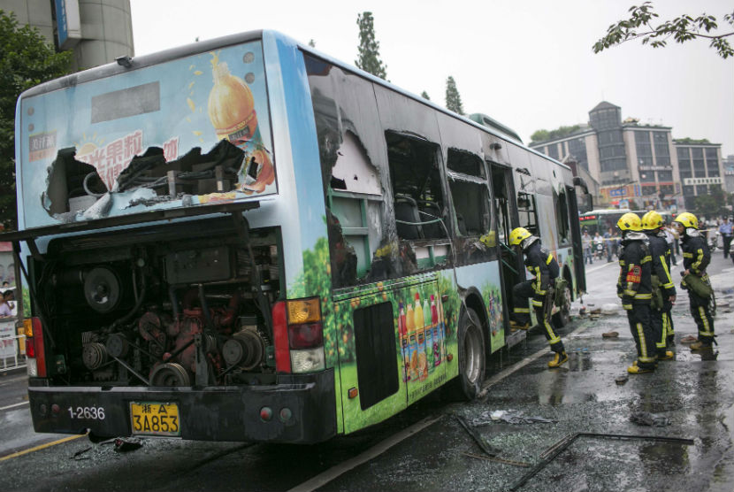 Petugas pemadam kebakaran memadam api yang membakar sebuah bus di jalanan Kota Hangzhou, Zhejiang, Cina, Sabtu (5/7).  