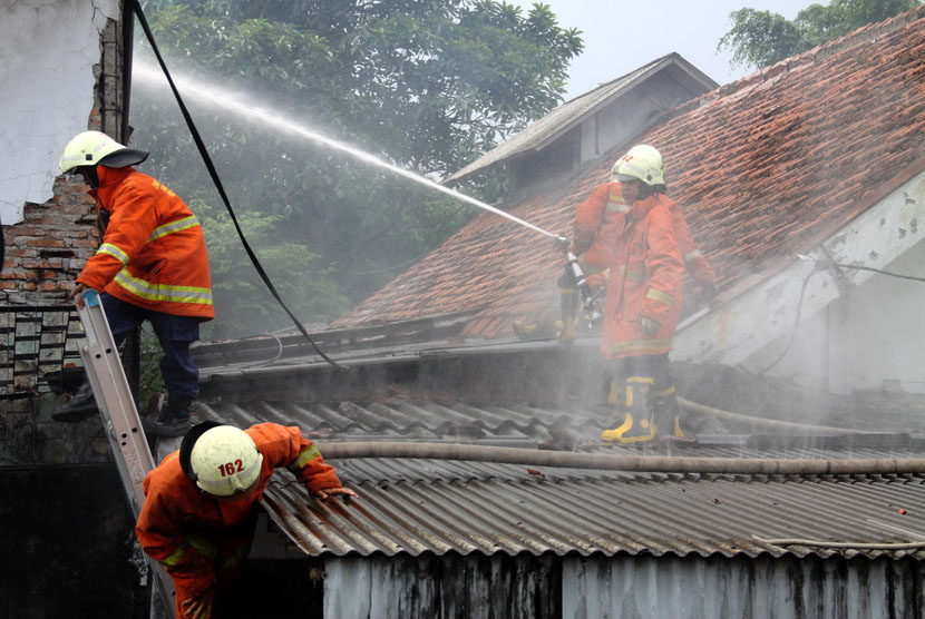 Petugas pemadam kebakaran memadamkan api saat kebakaran yang melanda sebuah rumah. (ilustrasi) 