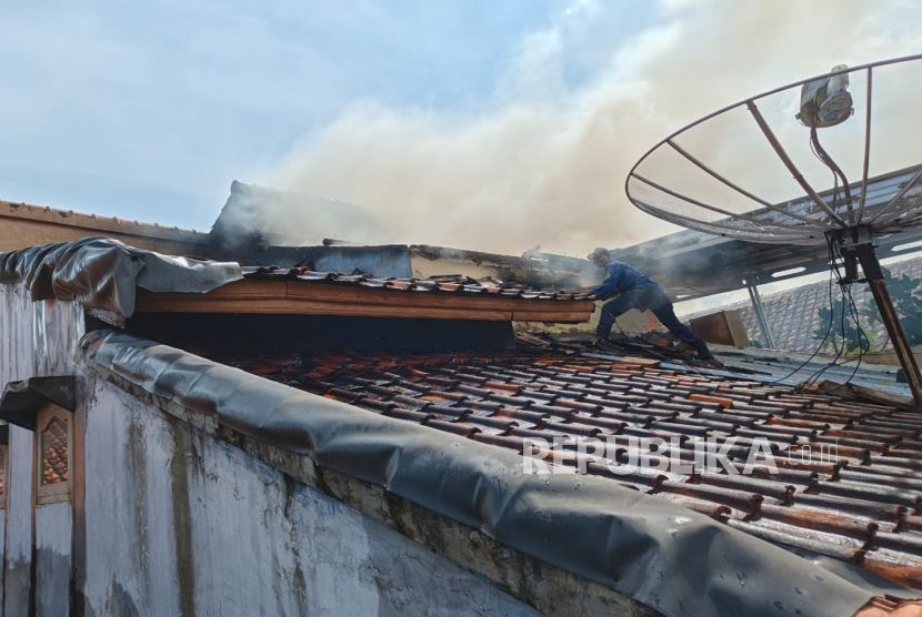 Petugas pemadam kebakaran memadamkan api yang melalap sebuah rumah milik warga di Jalan Veteran Kelurahan Kuningan, Kecamatan/Kabupaten Kuningan, Ahad (14/9/2025). 