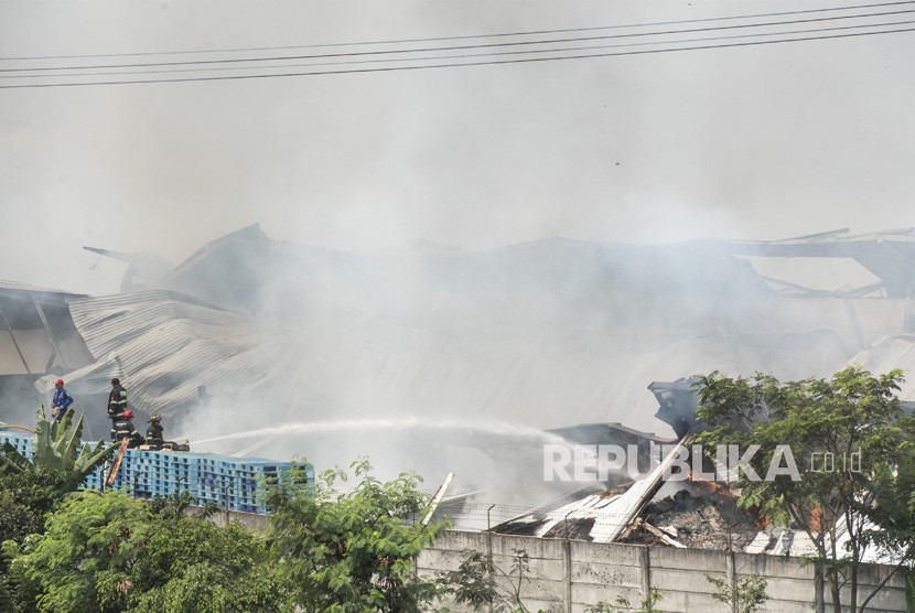 Petugas pemadam kebakaran memadamkan api yang membakar gudang di Deyuhkolot, Kabupaten Bandung, Jawa Barat, Kamis (31/5). 