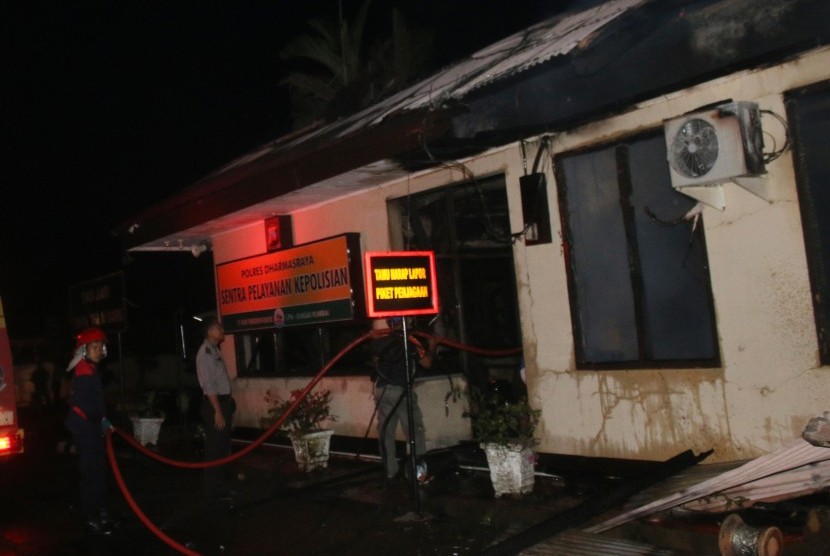 Petugas pemadam kebakaran, memadamkan api yang membakar Polres Dharmasraya, Sumatera Barat, Ahad (12/11) dini hari. 
