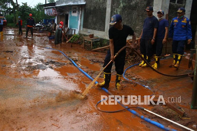 (ILUSTRASI) Petugas membantu membersihkan lumpur sisa banjir. 