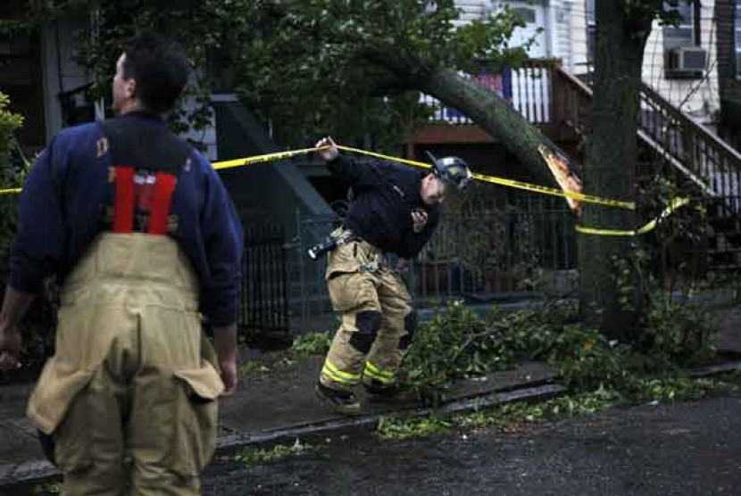  Petugas pemadam kebakaran memeriksa pohon tumbang akibat badai Sandy di Jersey City, New Jersey, Senin (29/10) waktu setempat. 