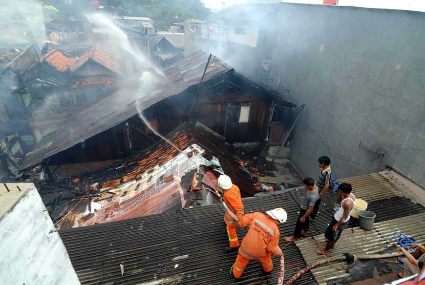  Petugas pemadam kebakaran mencoba memadamkan api saat kebaran di pemukiman padat di Kelurahan Kramat, Senen, Jakarta Pusat, Jumat (24/8). (Wihdan Hidayat/Republika)