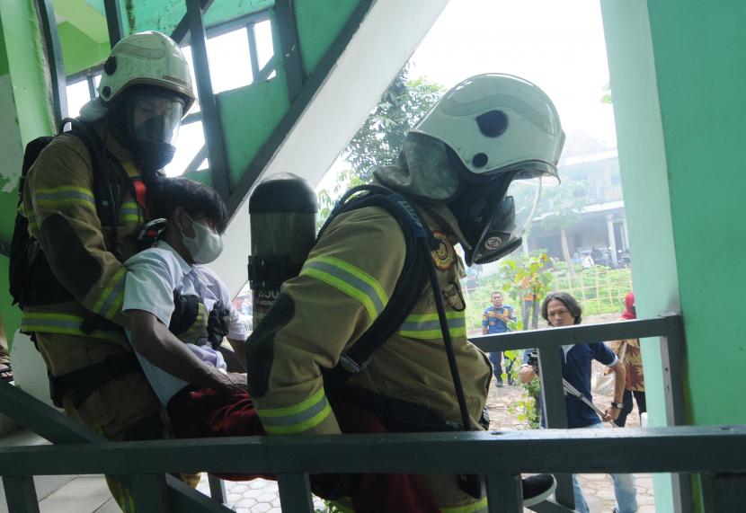 Petugas mengevakuasi seorang siswa berkebutuhan khusus saat simulasi penyelamatan dalam kebakaran di SLB BC Dharma Anak Bangsa, Ceper, Klaten, Jawa Tengah, Senin (31/10/2022). (Ilustrasi)