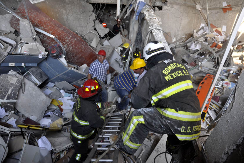 Petugas pemadam kebakaran menggali reruntuhan ledakan di sebuah bangunan yang berdekatan dengan gedung Pemex, perusahaan minyak milik negara di Mexico City, Kamis (31/1).  (AP/Guillermo Gutierrez)